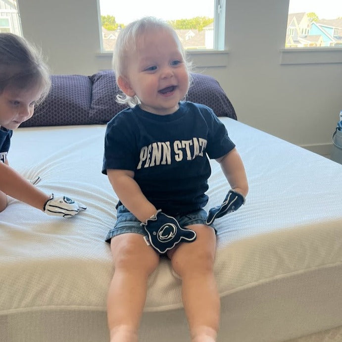 Baby wearing Penn State We Are baby mittens in blue