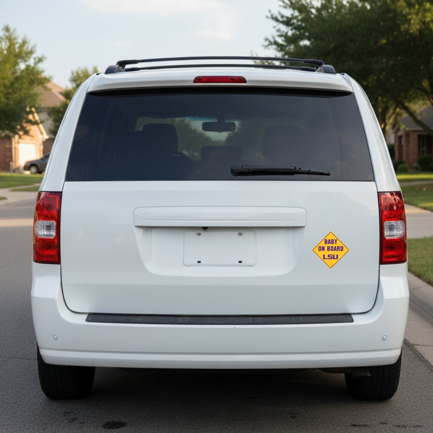 White van with a 'Baby on Board' sign on the back, parked on a street.