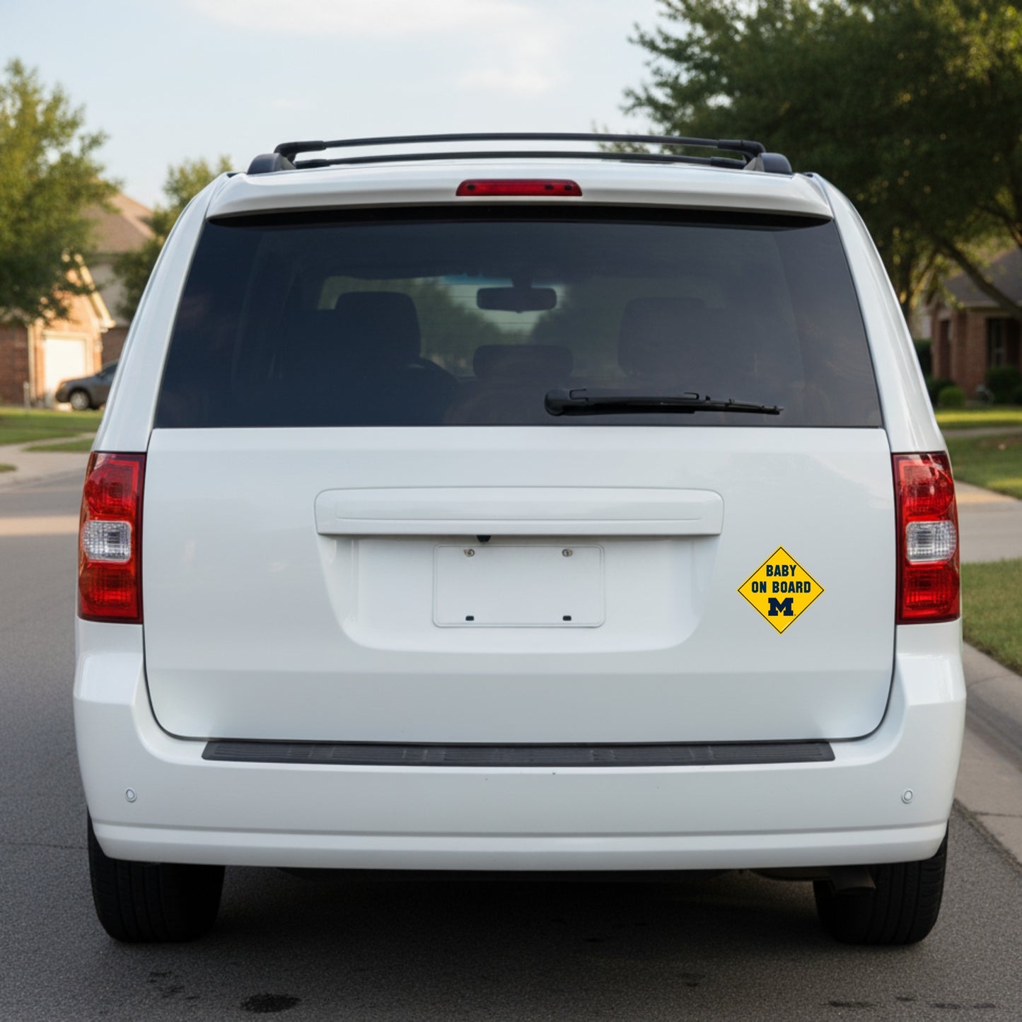 White van with a 'Baby on Board' sign on the back, parked on a street.