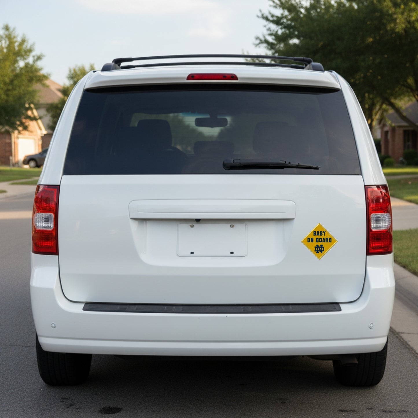 White van with a 'Baby on Board' sign on the back, parked on a street.