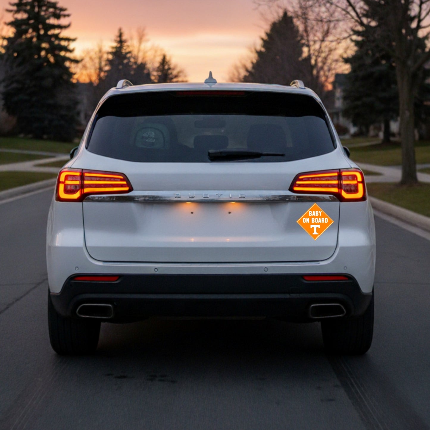 White SUV with a 'Baby on Board' with Tennessee Volunteers logo at sunset