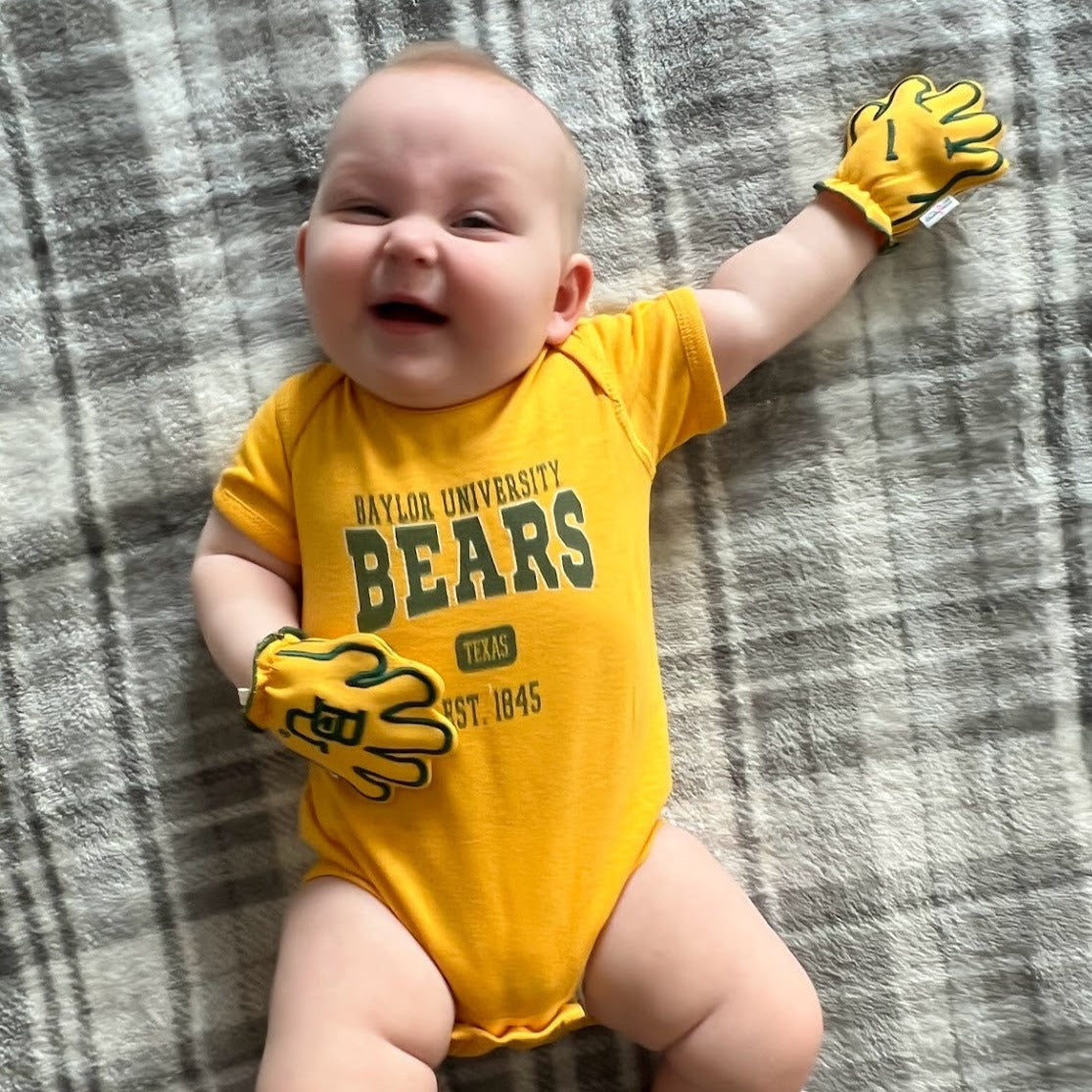 Infant wearing Baylor Sic Em baby mittens in gold