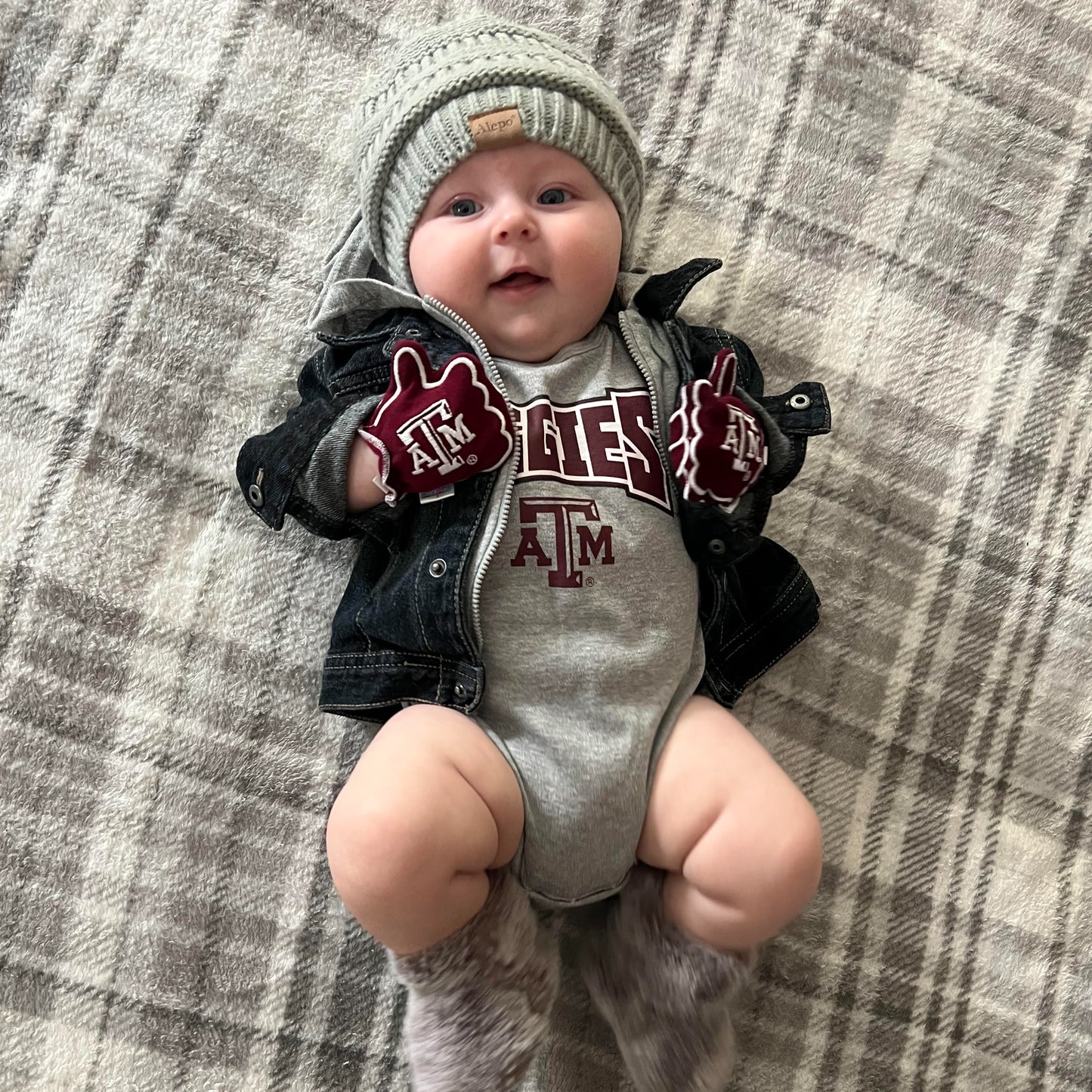 Newborn wearing Texas A&M Gig Em baby mittens in maroon