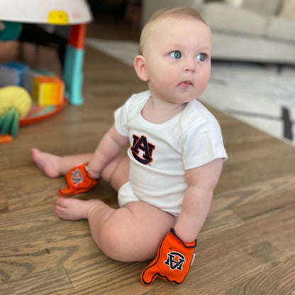 Infant wearing Auburn War Eagle baby mittens in Orange