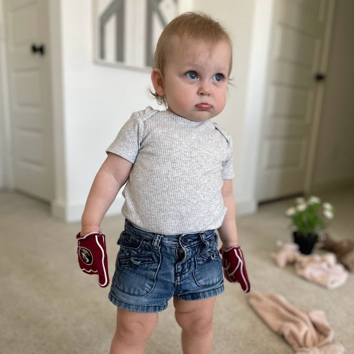 Baby wearing FSU Scalp Em baby mittens in garnet red