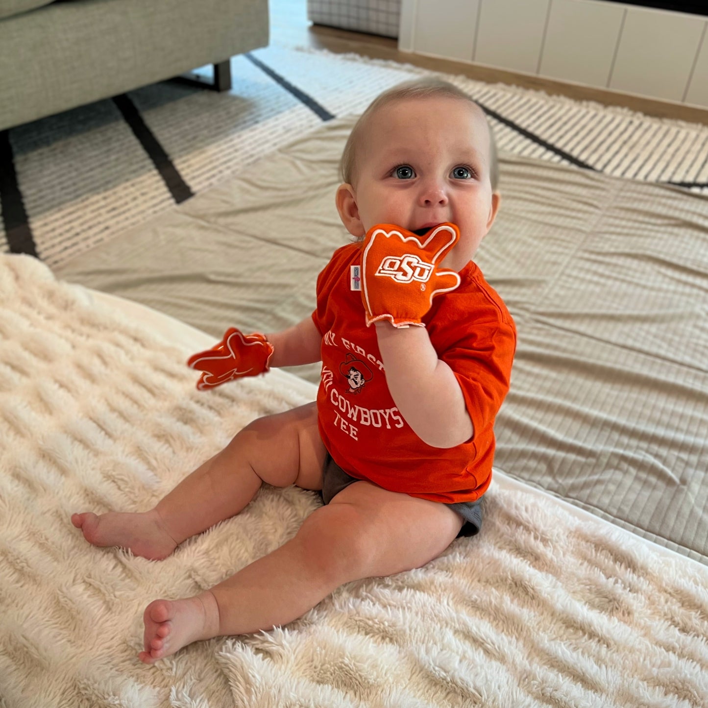 Infant wearing Oklahoma State Go Pokes baby mittens in Orange