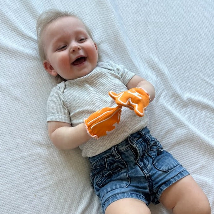 Baby wearing Tennessee Go Vols baby mittens in orange
