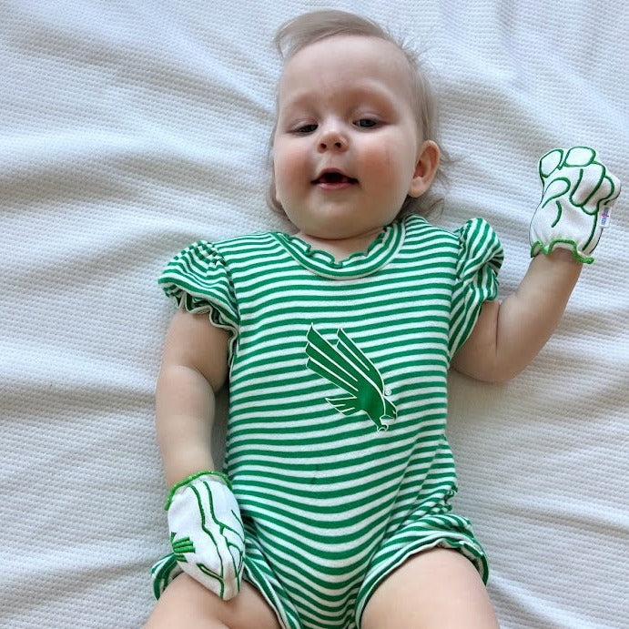 Baby wearing UNT Mean Green baby mittens in white