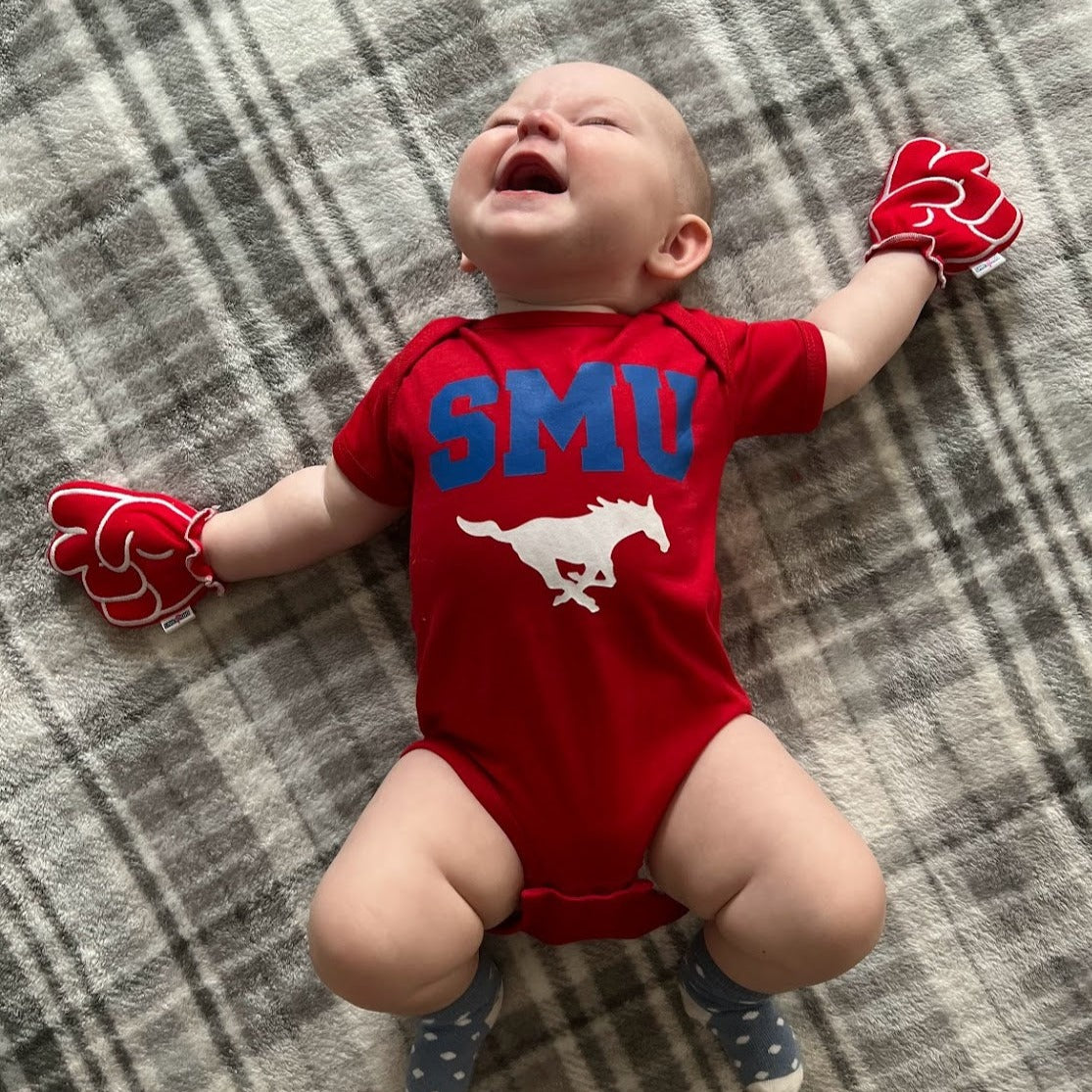 Infant wearing SMU Go Mustangs baby mittens in red